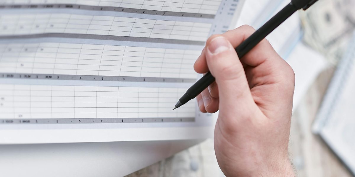 A person reviewing financial documents, emphasizing the importance of cost efficiency in AI projects.