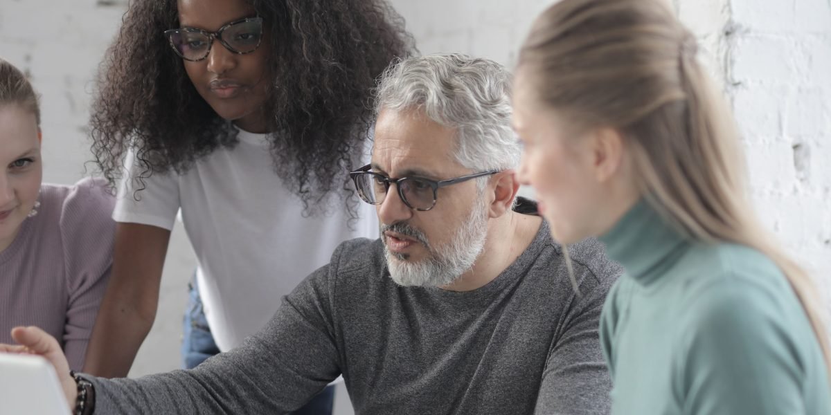 A diverse team collaborating on a project, symbolizing the shift from human as operator to human as collaborator with AI.