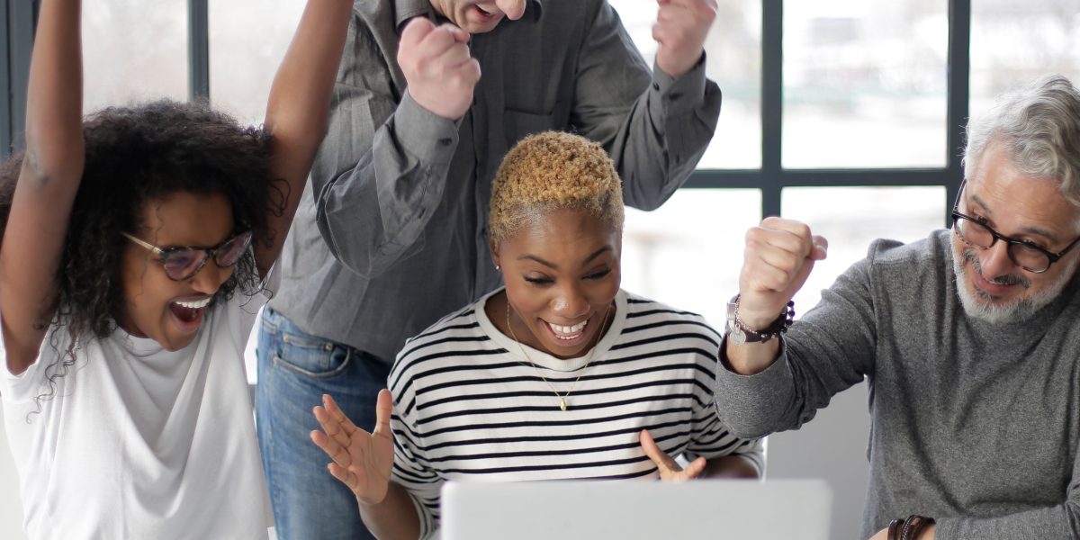 A team celebrates a project milestone, reflecting the enhanced productivity and quicker task completion enabled by AI coding tools in software development.