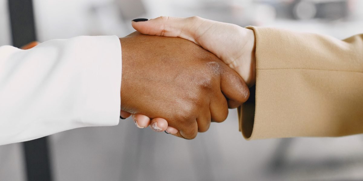 Two professionals finalizing a business partnership, symbolizing the impact of collaborations in tech.