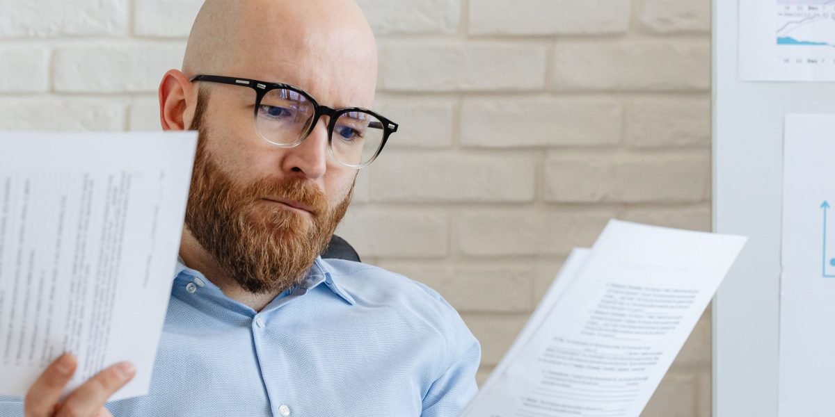 A person intently reviewing code or documents, emphasizing the need for human oversight even with AI assistance.