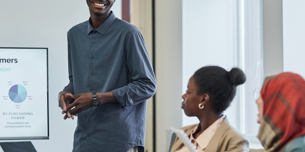 A confident professional presenting insights and value to a group of decision-makers.