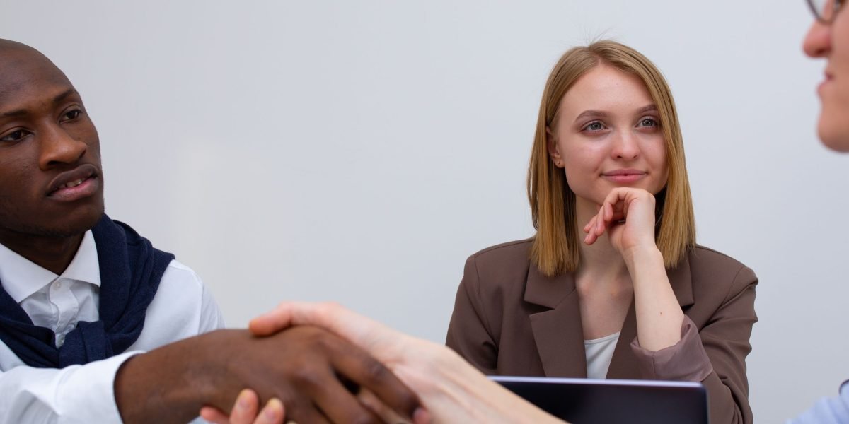 Two professionals engaging in a handshake, signifying a successful interview or the start of a new professional relationship.