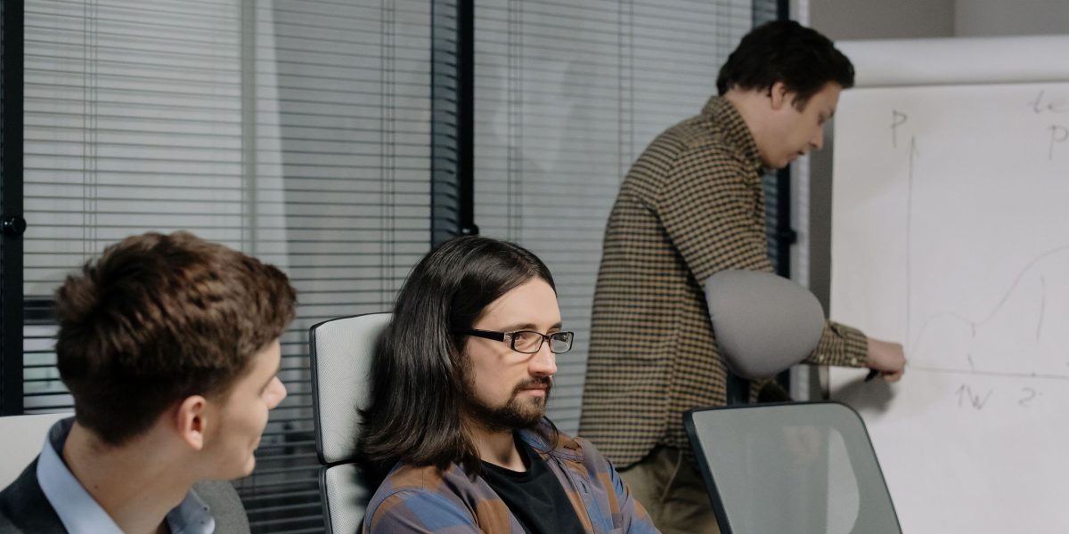 A team collaborates around a whiteboard, strategizing early-stage AI product development and testing.