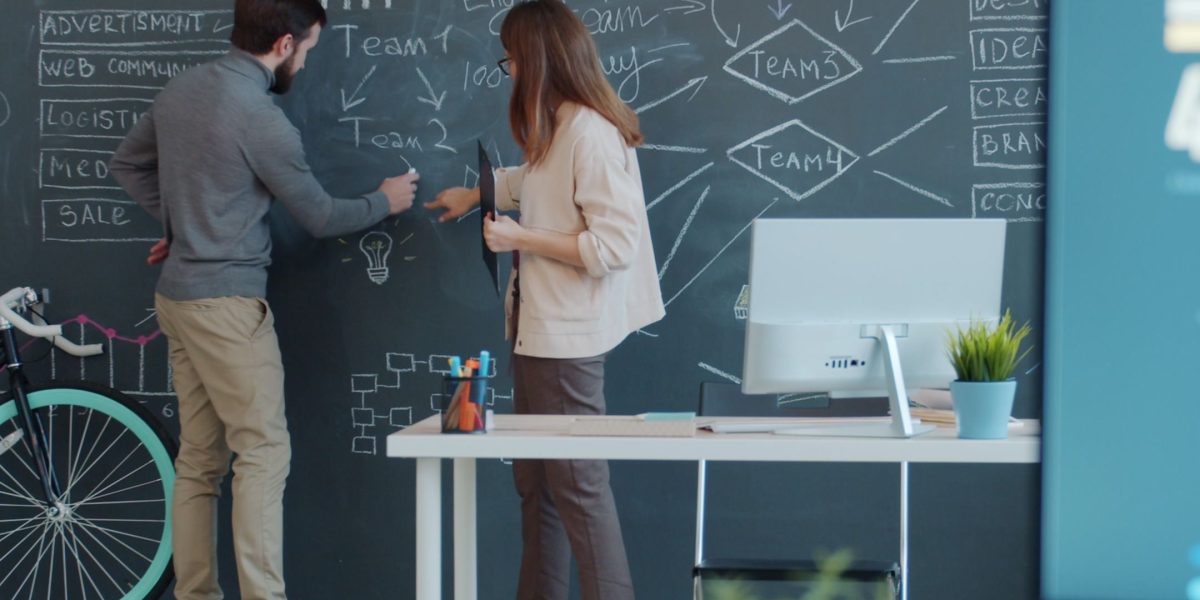 A team actively collaborating and brainstorming ideas on a whiteboard, reflecting accelerated growth.