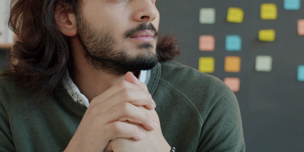 A person reflecting on strategic choices, symbolizing the challenge of navigating numerous new AI tools.