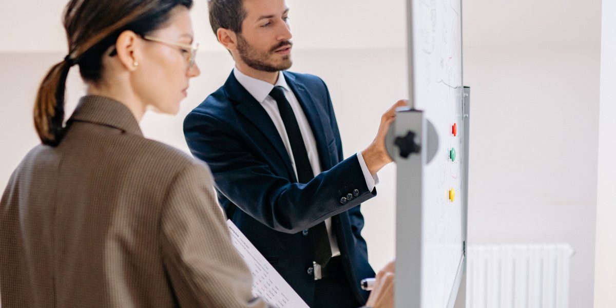 A team actively collaborating around a whiteboard, representing strategic discussions about market trends and tool adoption.